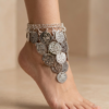 خلخال فضي شرقي مزين بعملات معدنية وخرز ملون على القدم Bracelet de cheville oriental argenté avec pièces métalliques et perles colorées porté au pied