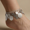 Silver oriental anklet with coin charms and colorful beads worn on foot خلخال فضي شرقي مزين بعملات معدنية وخرز ملون على القدم Bracelet de cheville oriental argenté avec pièces métalliques et perles colorées porté au pied