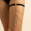 رباط فخذ أسود مع سلاسل ذهبية على الساق Black thigh band with gold chains worn on leg Bijou de cuisse noir avec chaînes dorées porté sur la jambe
