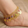 gold oriental anklet with coin charms and colorful beads worn on foot خلخال ذهبي شرقي مزين بعملات معدنية وخرز ملون على القدم Bracelet de cheville oriental dore avec pièces métalliques et perles colorées porté au pied