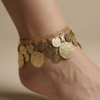 gold oriental anklet with coin charms and colorful beads worn on foot خلخال ذهبي شرقي مزين بعملات معدنية وخرز ملون على القدم Bracelet de cheville oriental dore avec pièces métalliques et perles colorées porté au pied